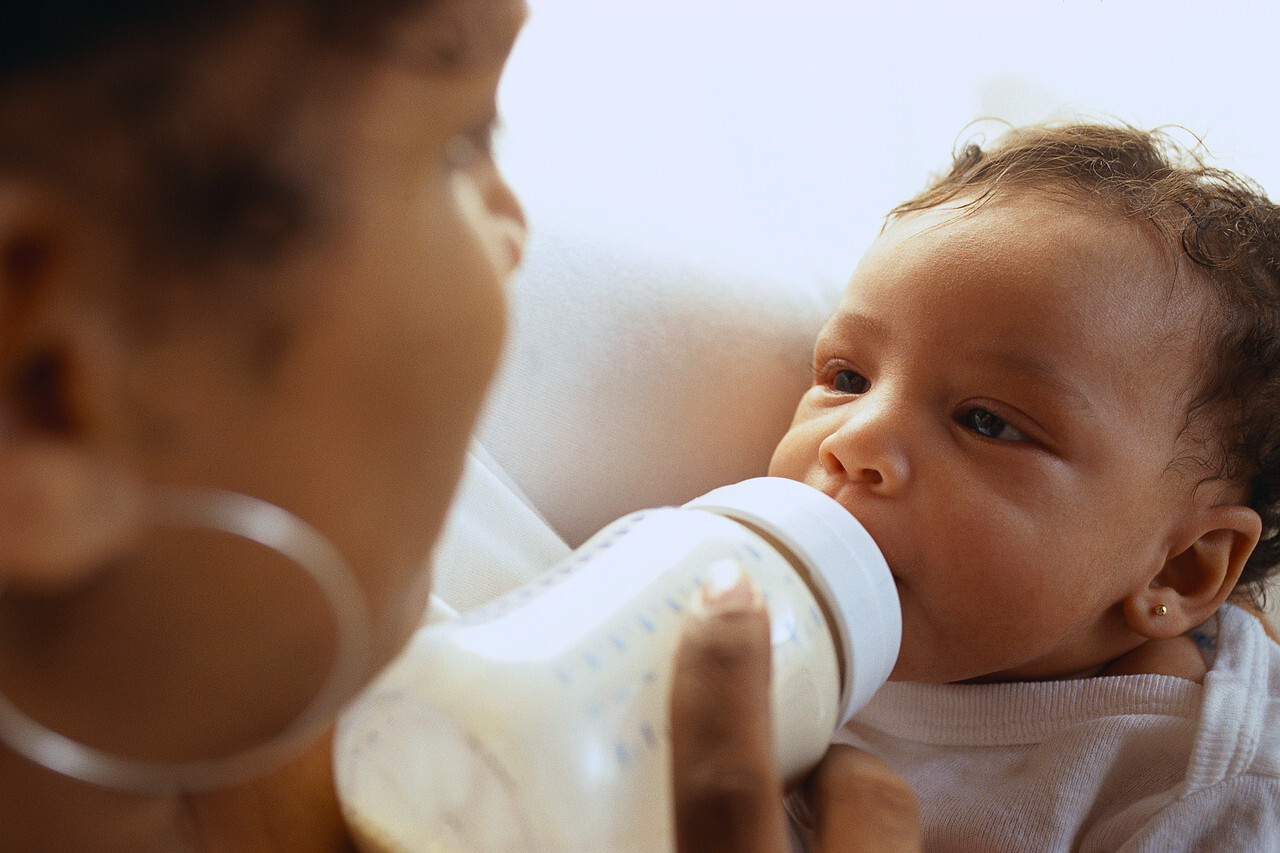 Baby being bottle fed by his mum