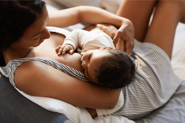 Mother breastfeeding her baby on the couch