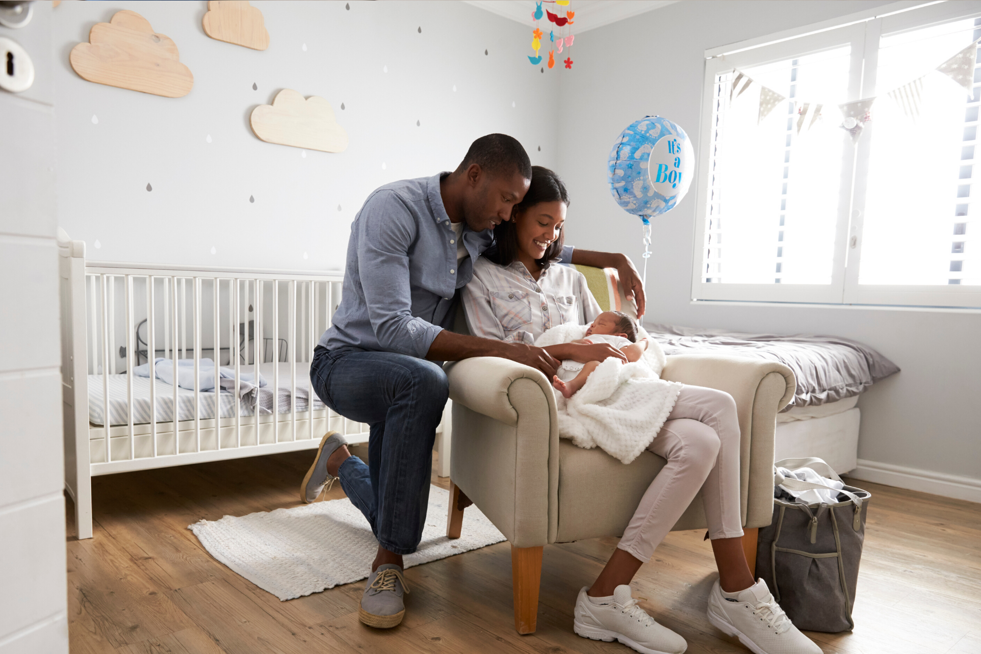 Parents smiling in nursery while newborn baby sleeps