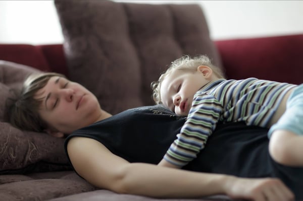 Toddler and mother asleep on the sofa 