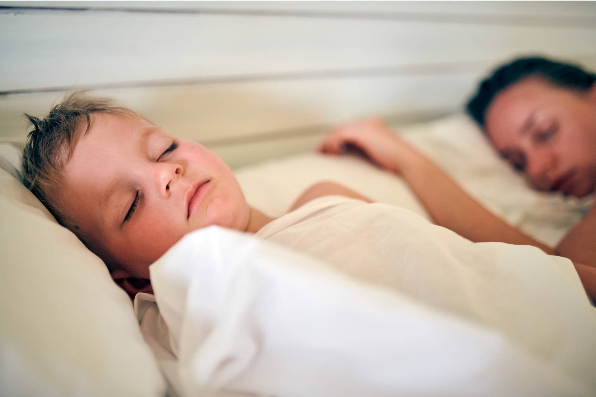 Toddler asleep next to sleeping parent 