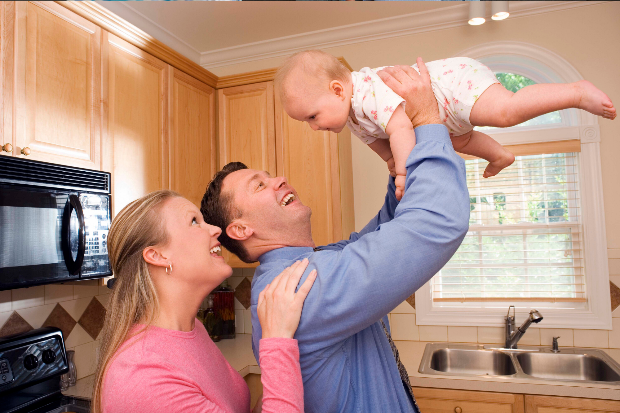 Parents engaging with baby in the kitchen