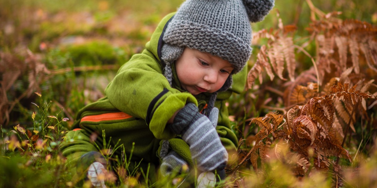 Autumn blog featured image little boy playing with Autumn leaves