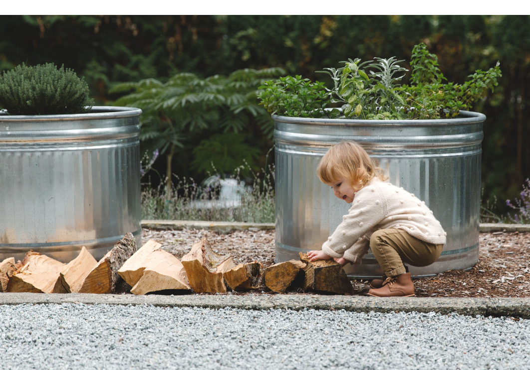 Kid helping move wood pieces in the garden