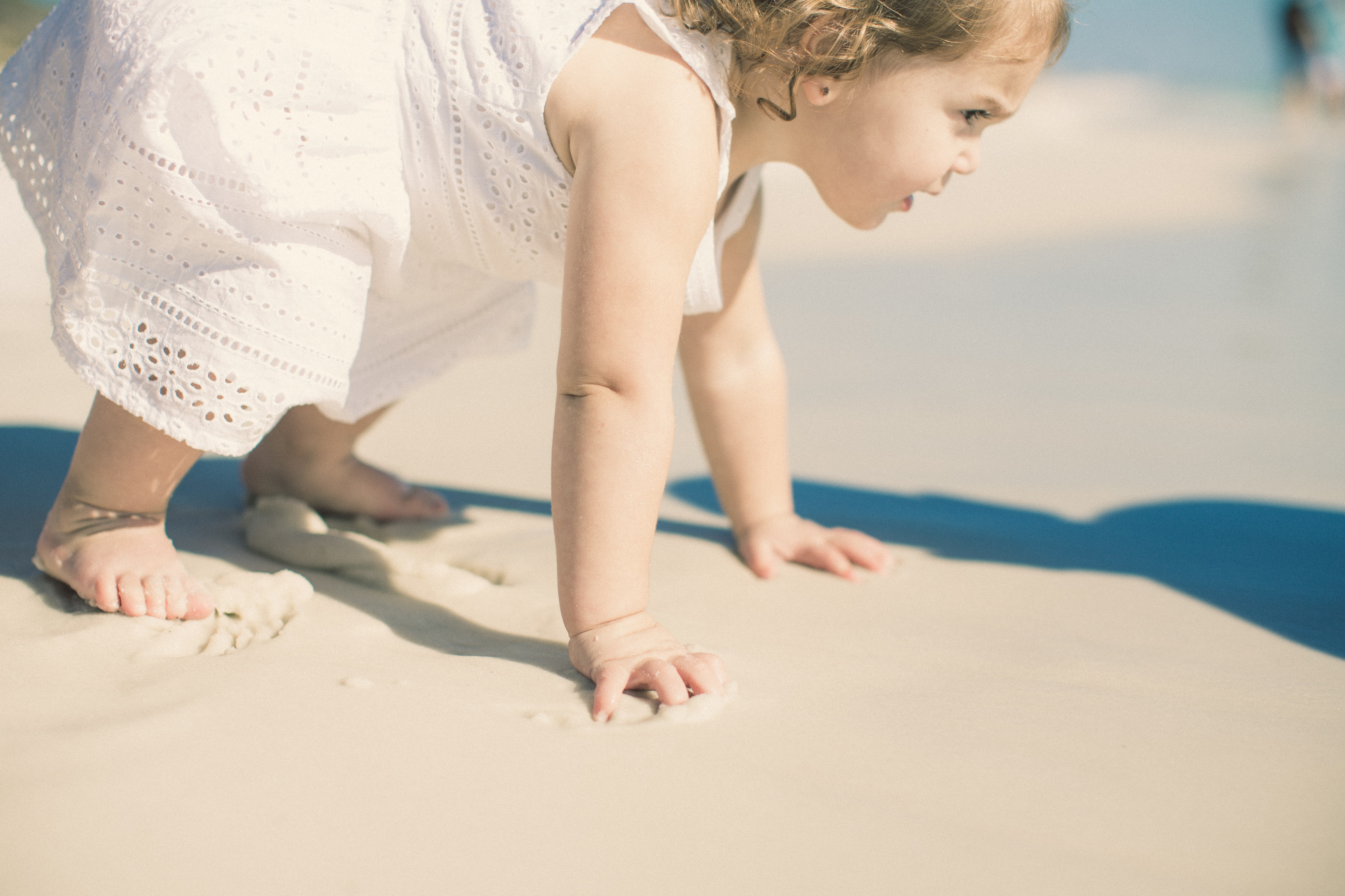 Little girl playing with sand on the beach