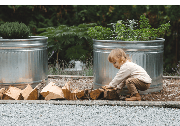 Kid helping move wood pieces in the garden