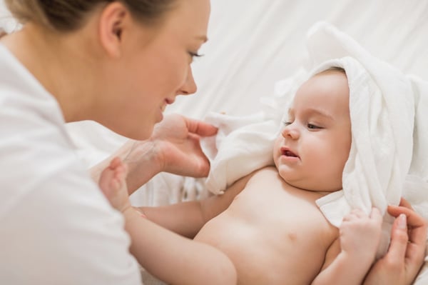 Mother cuddling her baby in a towel