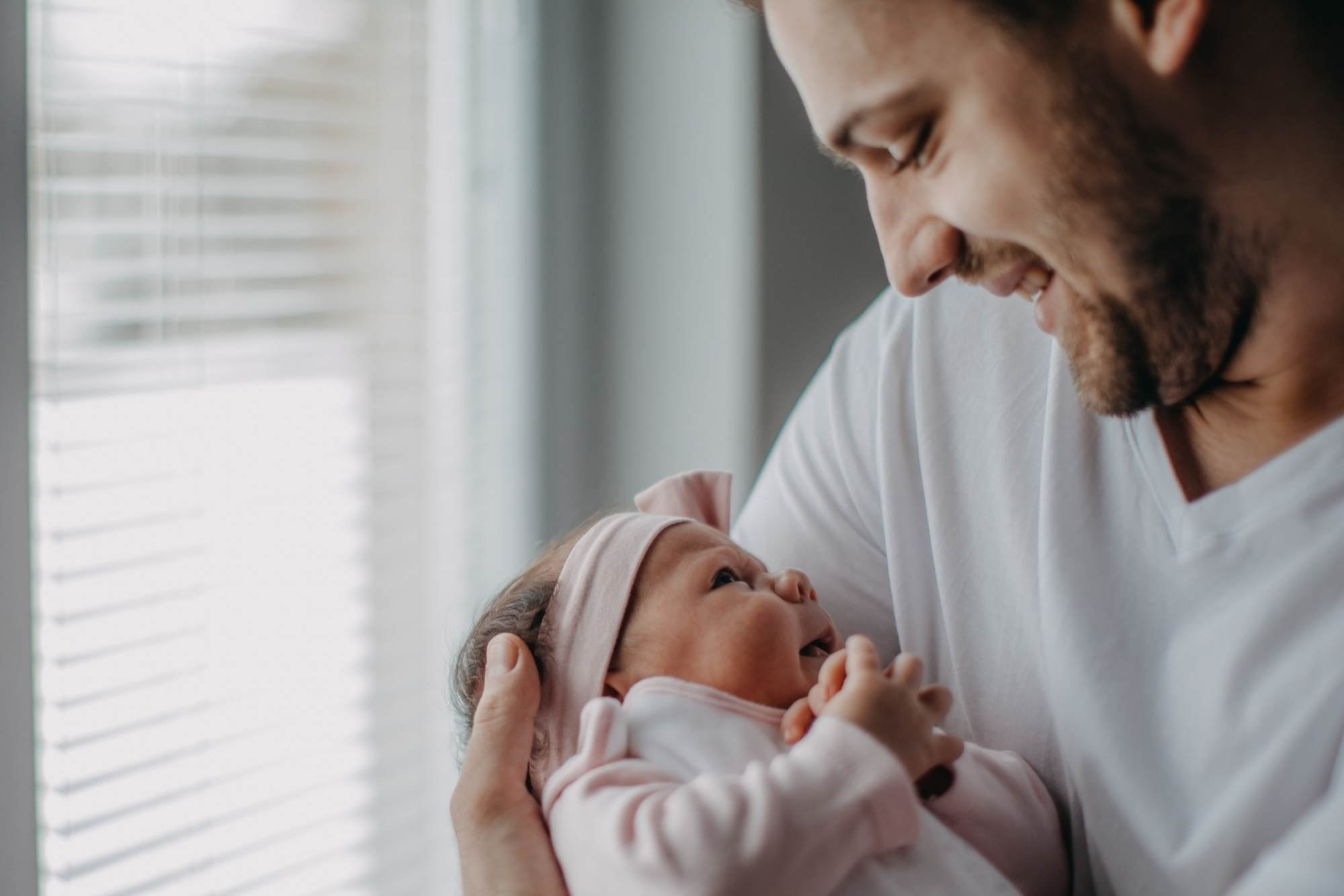 Dad smiling at his baby that he is holding in his arms