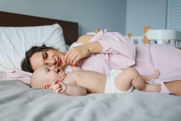 mother in bed at home with her baby