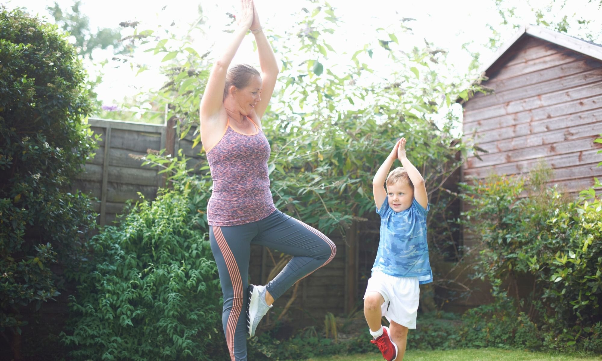 adult and child doing yoga poses outside