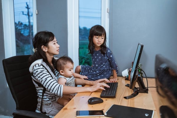 Mum with baby on lap working 