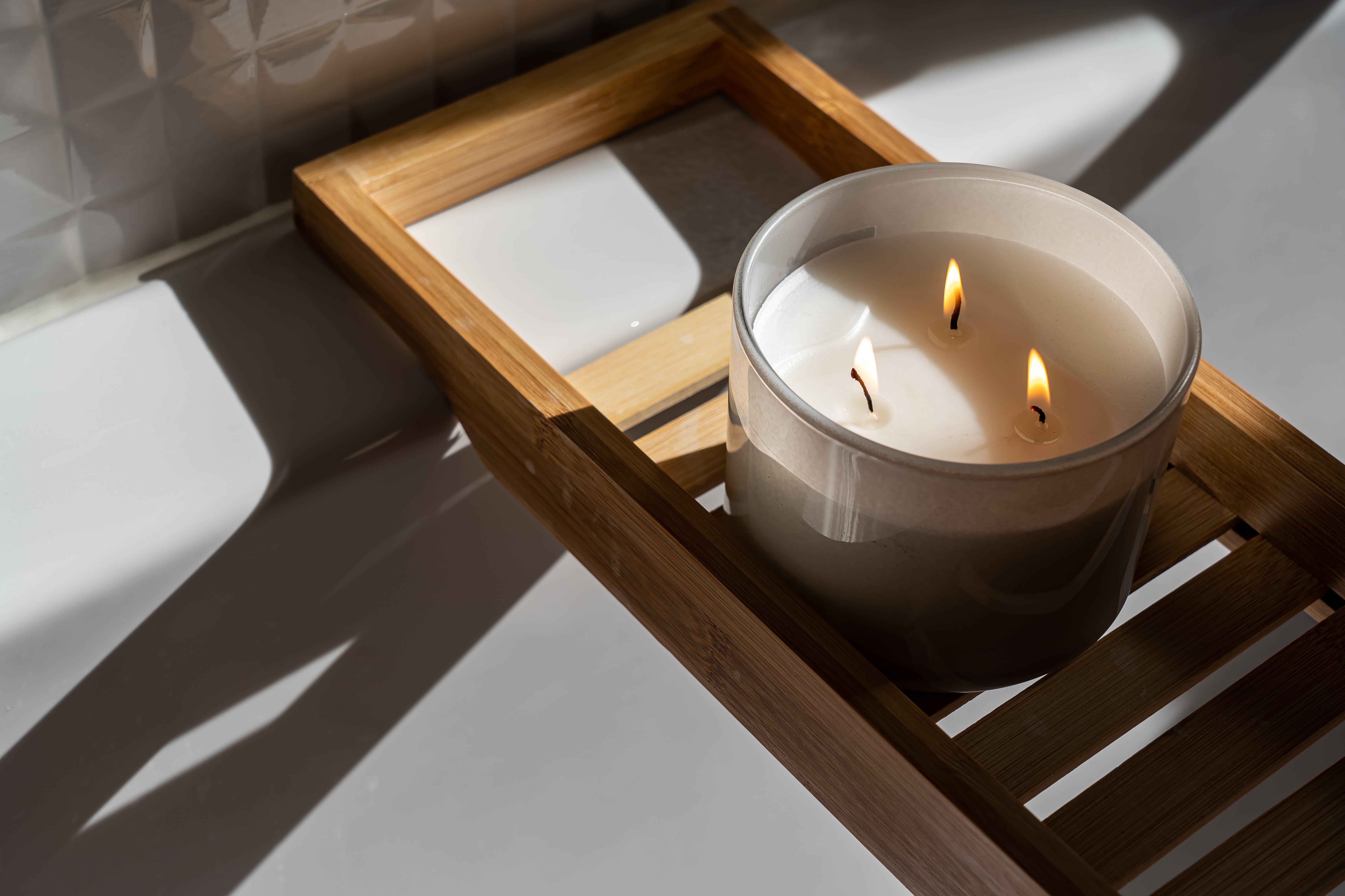 A burning candle on a wooden tray