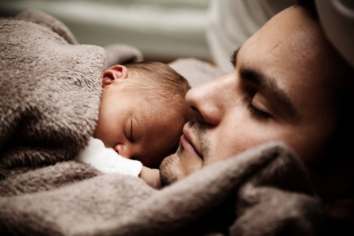 Father resting with his newborn baby