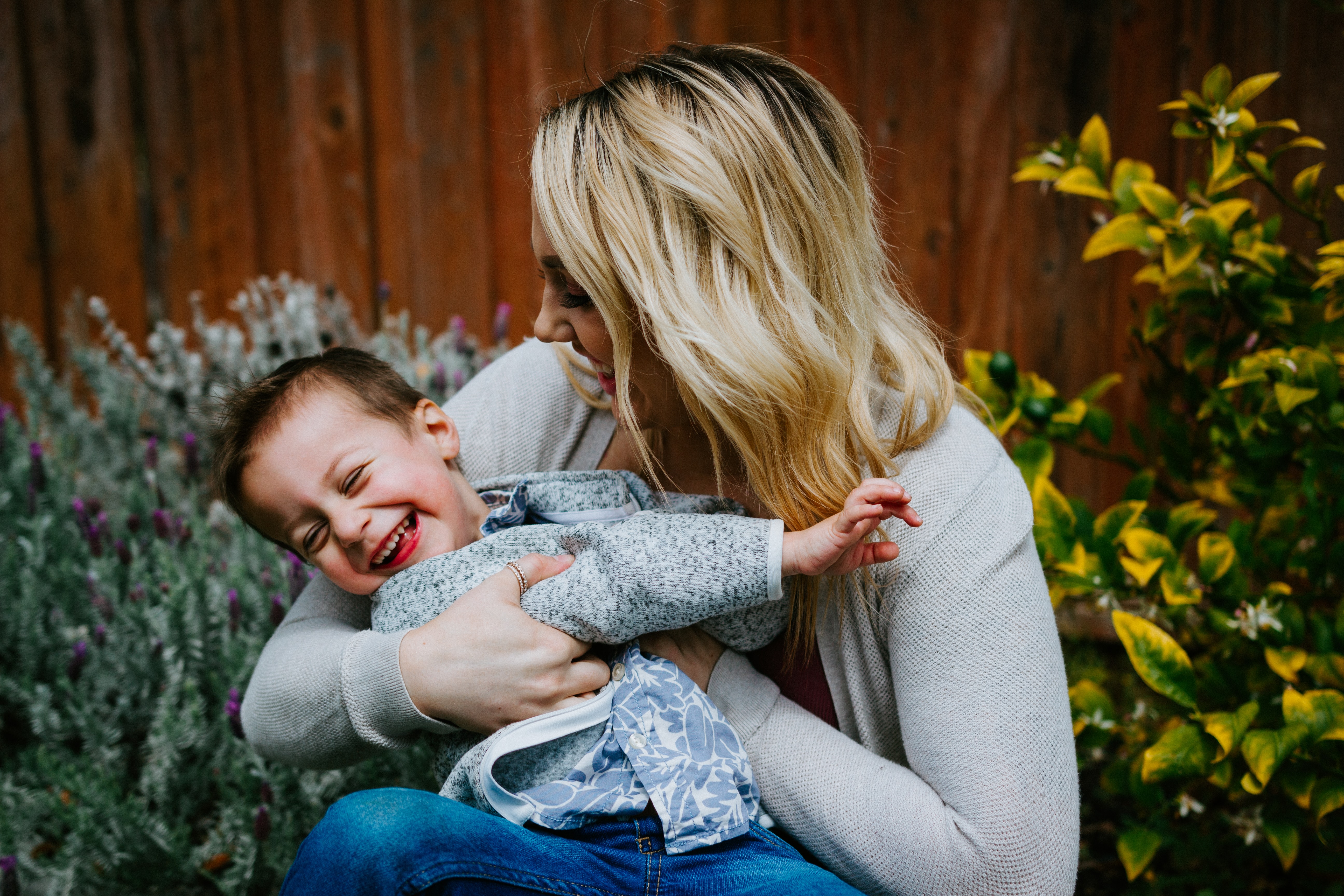 Parent and child hugging and laughing with each other in the garden