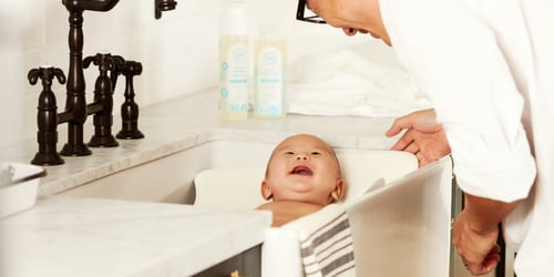Parent enjoying bathing their baby