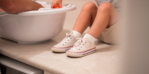 Child's legs and feet wearing converse trainers