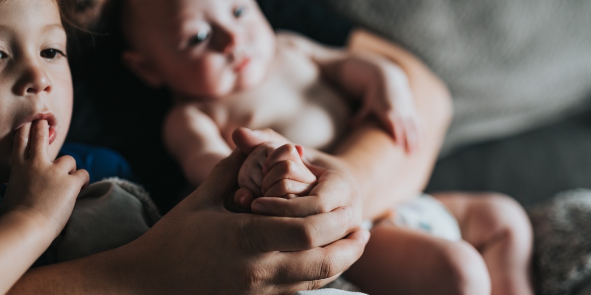 a toddler and a baby being cuddled before bedtime