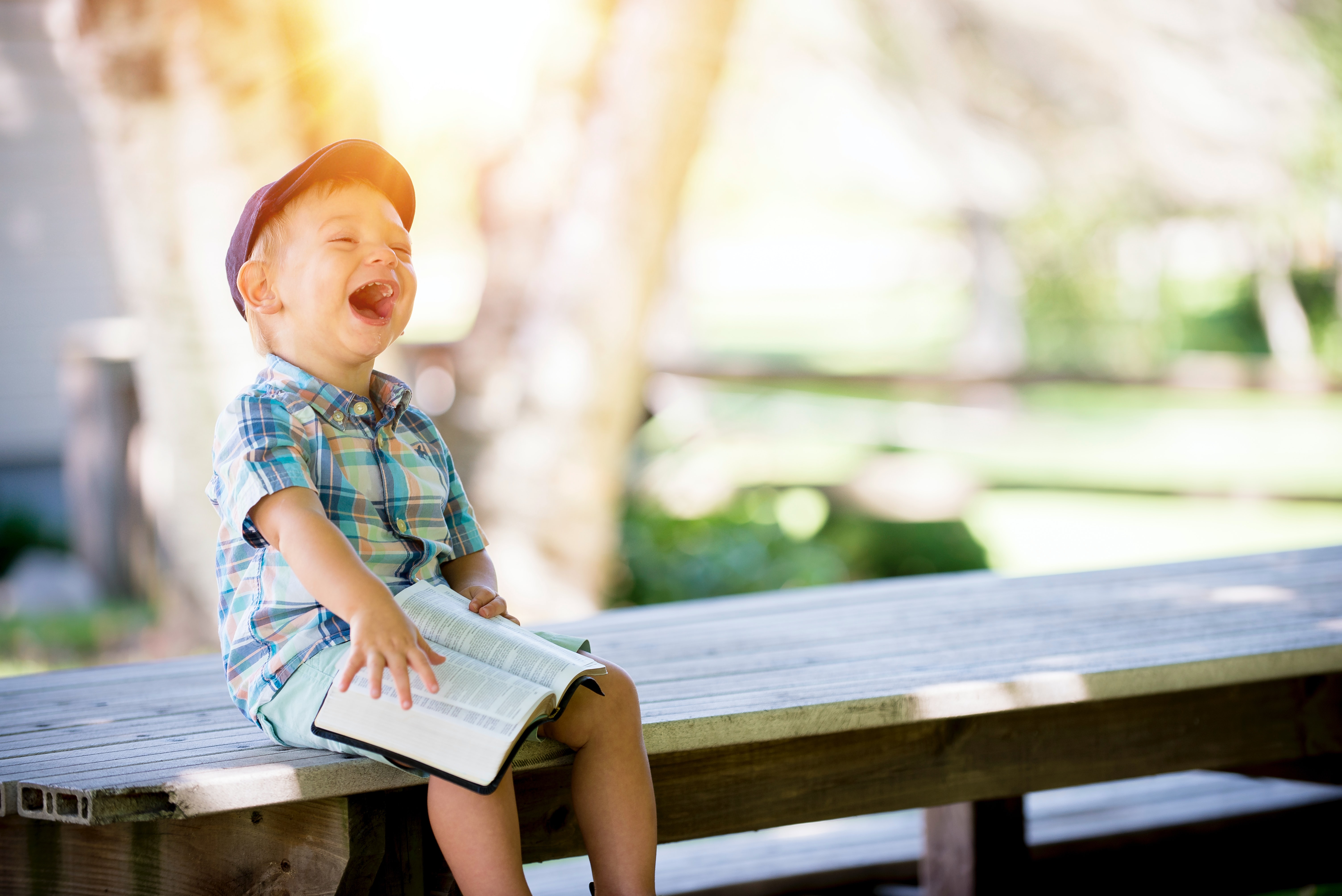 Laughing child sitting on a bench in the school yard