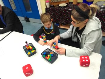 Parent and child at Lister Infants school building a tower with DUPLO bricks