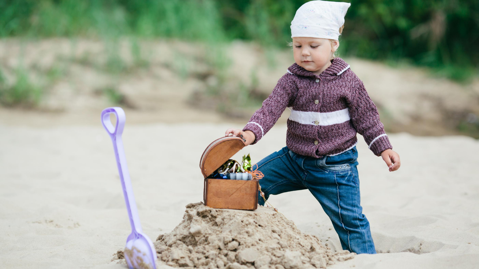 Kid finding a treasure box during a treasure hunt at the beach