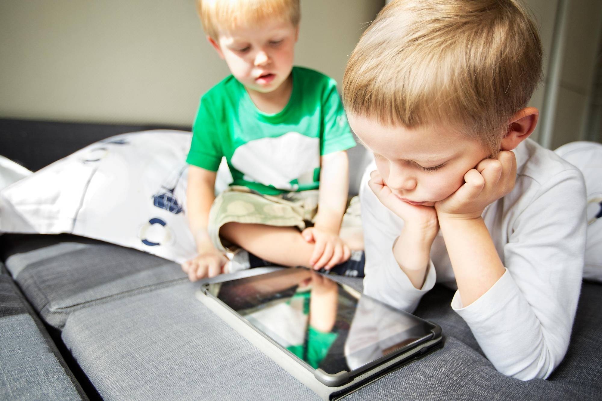 Toddlers reading an e-book on an electronic device