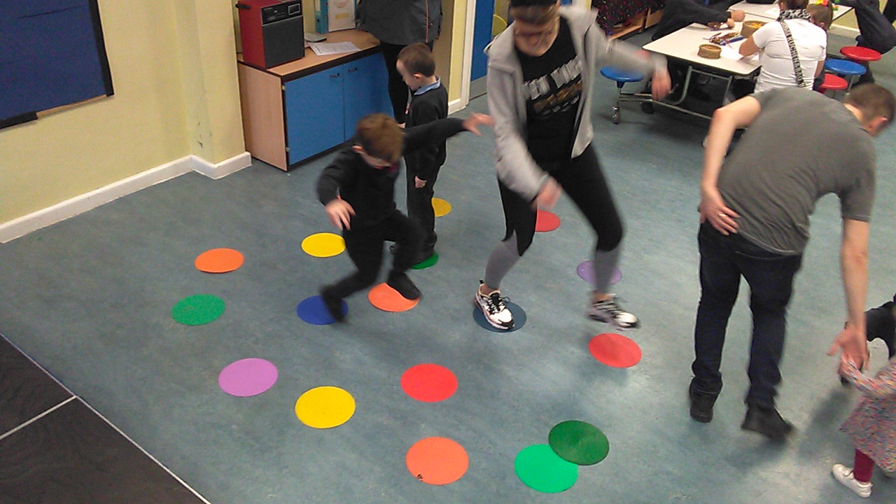 Parent and child at Lister Infant school play stepping stones using coloured circles