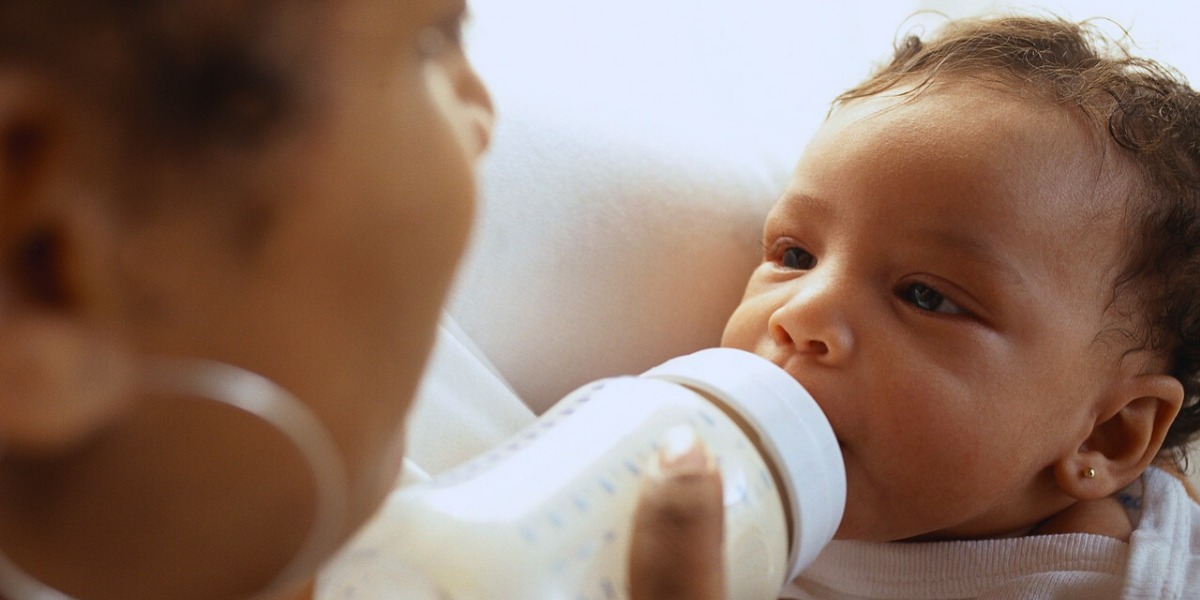 Mother bottle feeding formula to her baby 